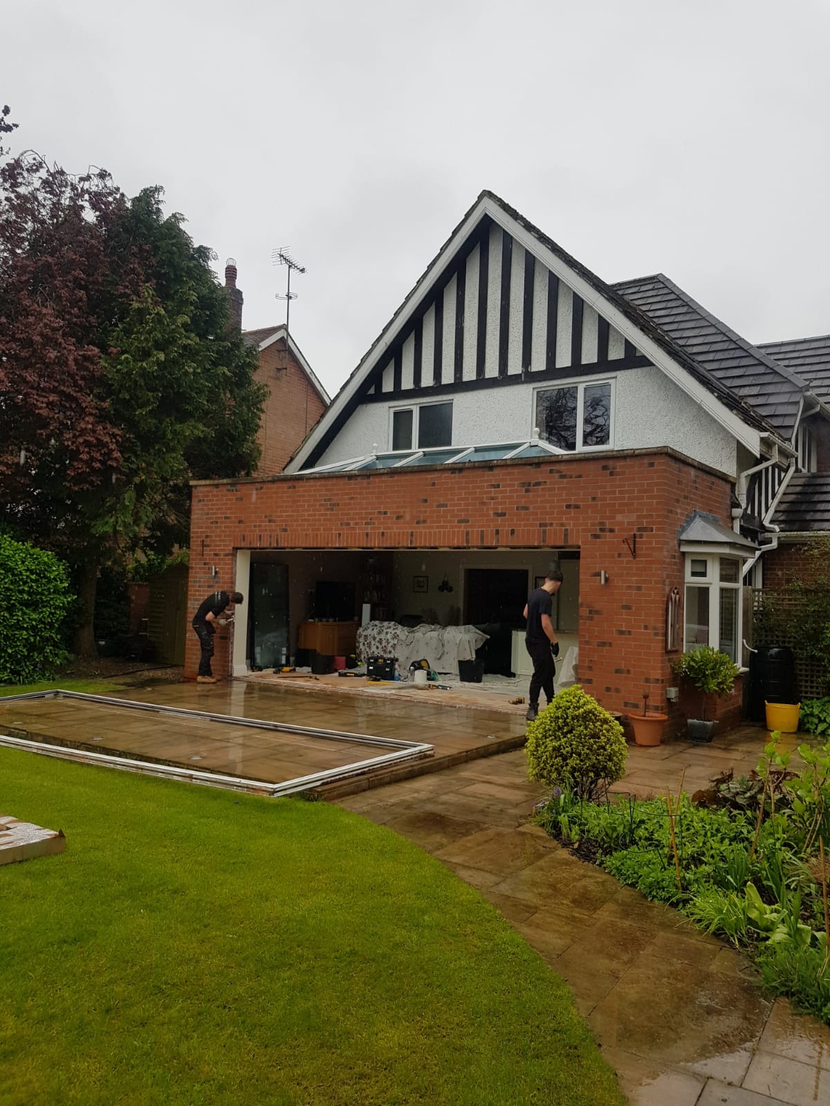 Brick house extension with six-panel anthracite grey bifold doors seen from the garden