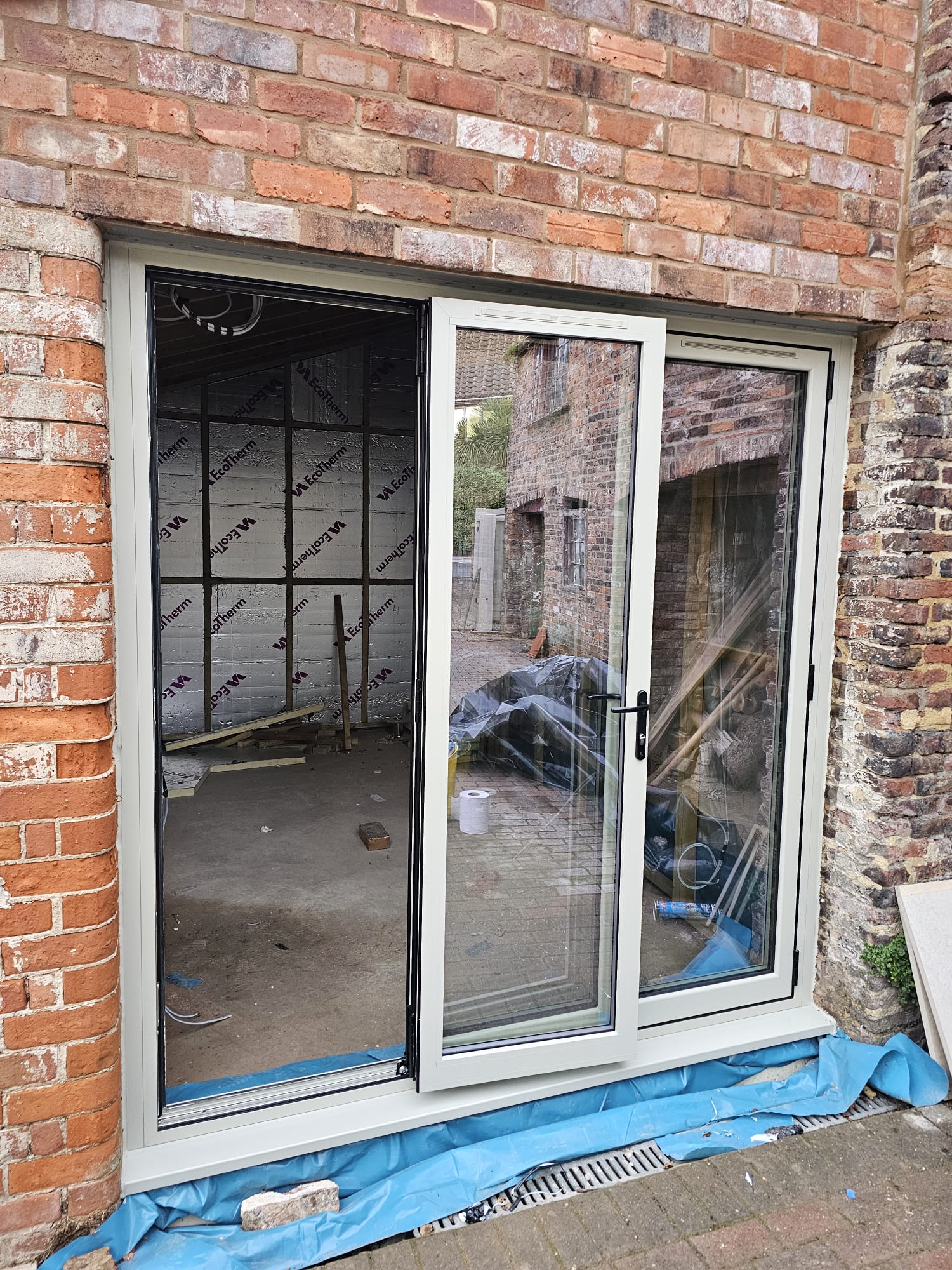 Interior view of three-panel pebble grey bifold doors with the lead door open