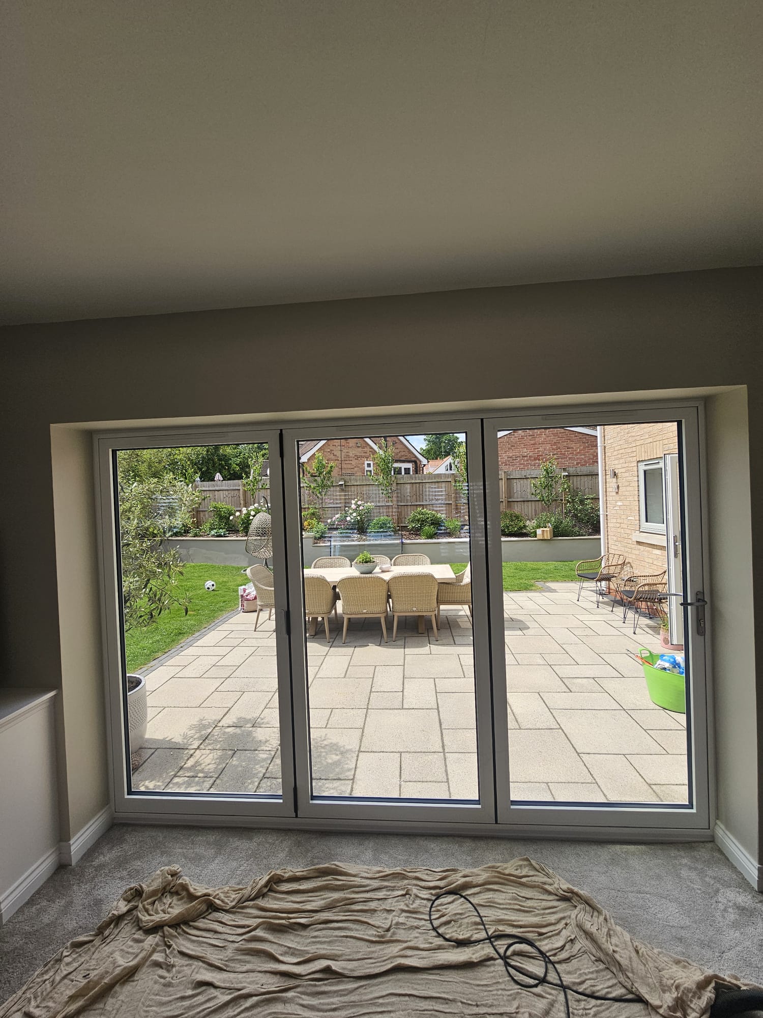 Interior view of closed three-panel agate grey bifold doors looking onto a garden