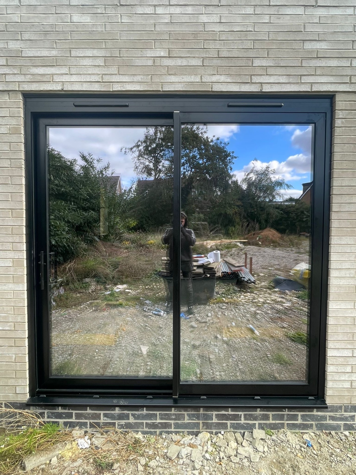 Installed black ALUNA sliding patio door viewed square-on from outside