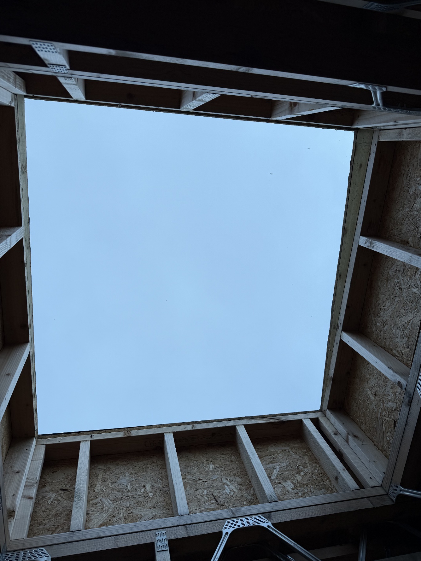 Interior view looking up through a large rectangular flat rooflight