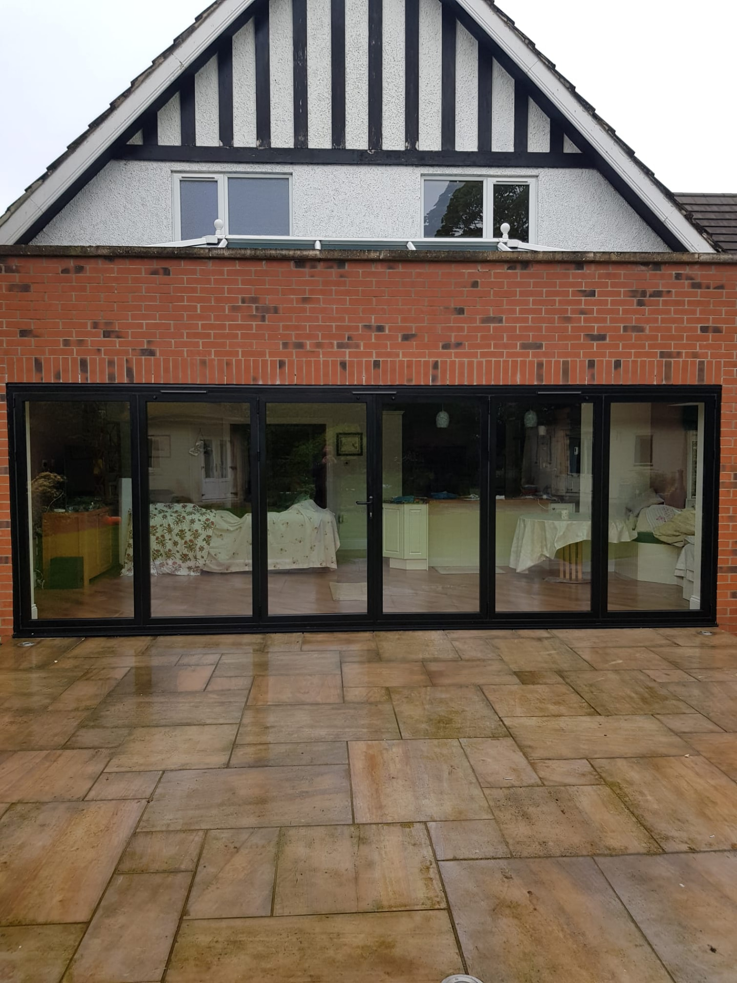 Six-panel anthracite grey aluminium bifold doors on a brick house extension