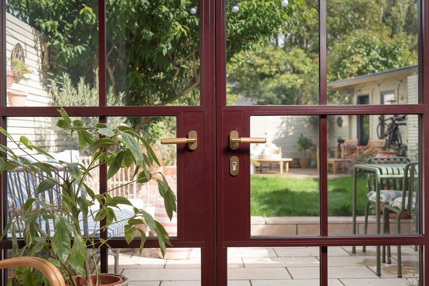 Origin steel-look aluminium French doors with glazing bars, finished in a deep red