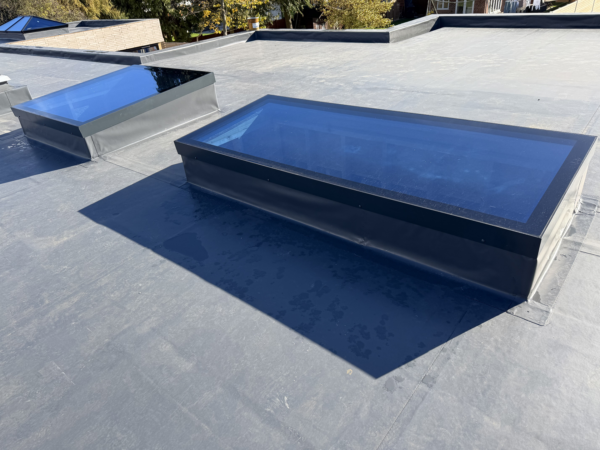 Two anthracite Infinity framed flat rooflights in sunlight