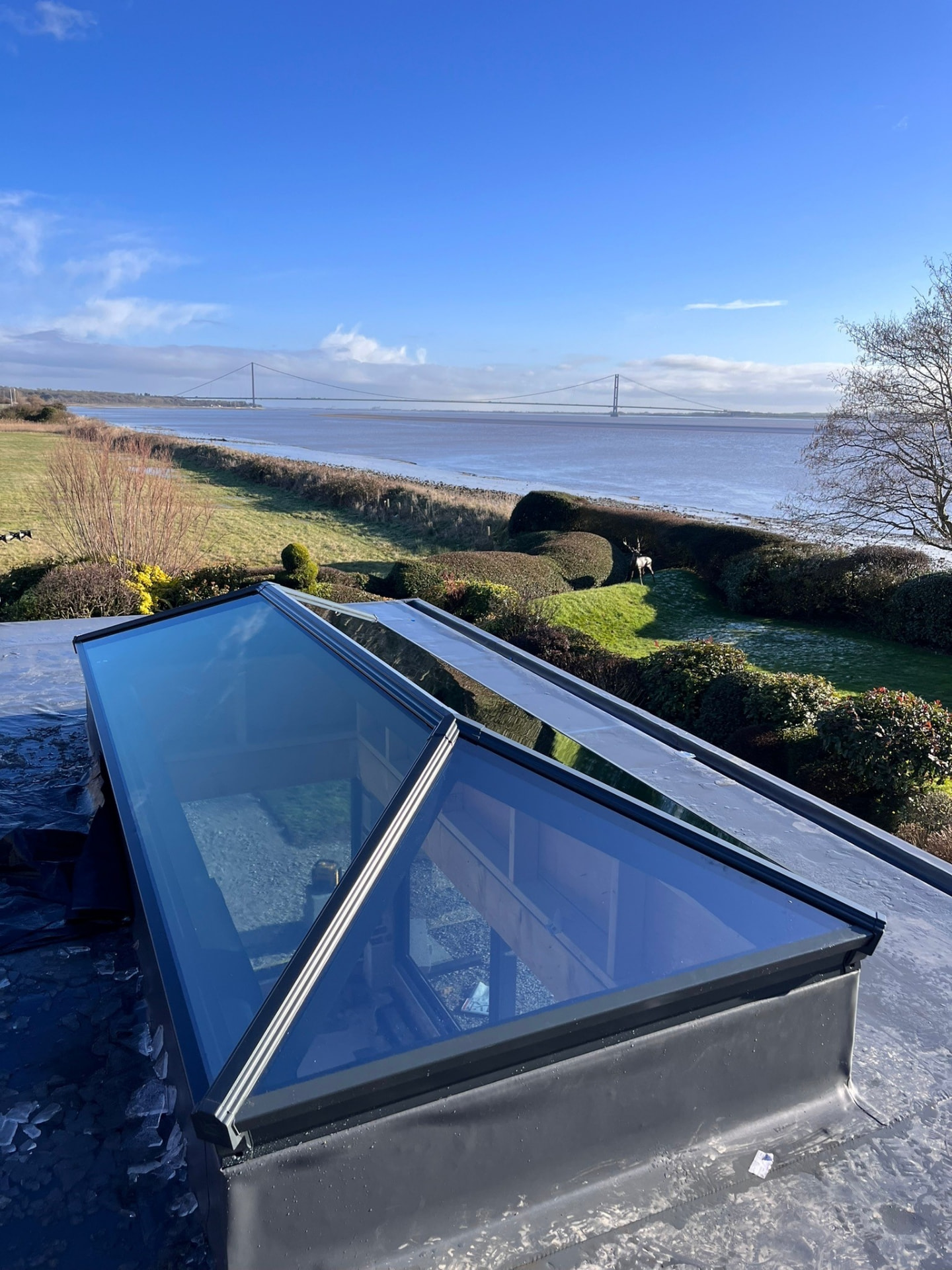 Korniche aluminium roof lantern installed on a flat roof with the Humber Bridge beyond